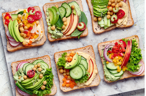 An array of colorful vegan avocado chickpea toasts topped
